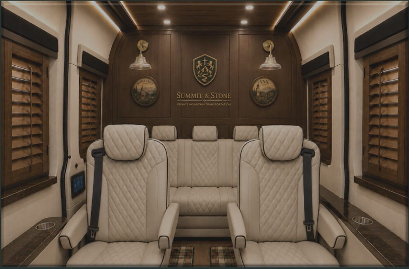 Seven diamond-stitched cream leather captain's chairs beneath brass sconces, the Summit and Stone crest set in walnut on the rear wall